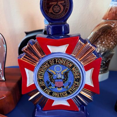 Sale Photo Thumbnail #16: Vintage ceramic Veterans of Foreign Wars 75th Anniversary commemorative decanter, featuring a red, white, and blue design with gold accents.