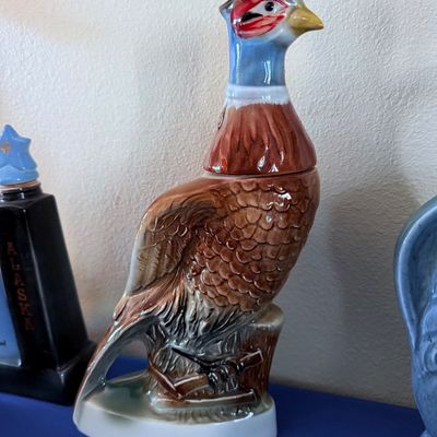 Sale Photo Thumbnail #18: Vintage ceramic pheasant decanter, likely a mid-century collectible liquor bottle, featuring detailed molded feathers and a colorful glazed finish.