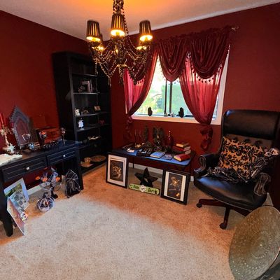 Sale Photo Thumbnail #23: Gothic-style home office furniture and decor, featuring a black leather high-back armchair, black wooden desks, a tall bookcase, and a black chandelier with beaded accents.