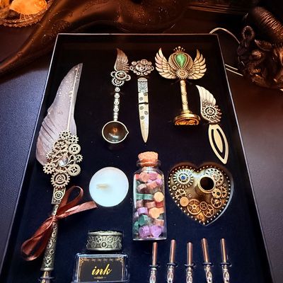 Sale Photo Thumbnail #5: Steampunk-themed calligraphy and wax seal set in a black presentation box, featuring a feather quill pen, ink bottle, wax melting spoon, stamp, and assorted metal nibs.
