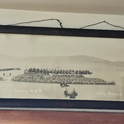Antique panoramic military photograph of the 137th Infantry Regiment at Camp Doniphan, Fort Sill, Oklahoma, housed in a simple dark wood...