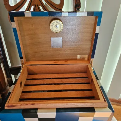 CAO "Montague" wooden cigar humidor featuring a blue, black, and silver geometric exterior, built-in hygrometer, and a...