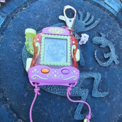 Vintage Littlest Pet Shop digital virtual pet toy, featuring a purple and orange plastic casing with a working LCD screen, keychain clip,...