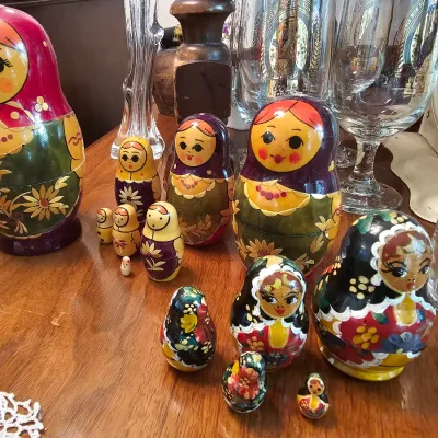 Two sets of vintage Russian nesting dolls, or matryoshka dolls, in varying sizes with hand-painted floral and traditional details.