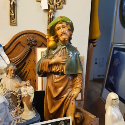 Vintage hand-painted plaster statue of Saint Roch, depicted with his staff, gourd, and dog, surrounded by other Catholic religious...