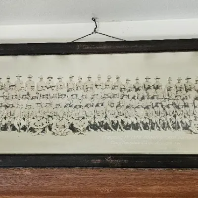 Vintage panoramic military group photograph of Company B, 137th Infantry, 35th Division, housed in a long, dark wooden frame with visible...