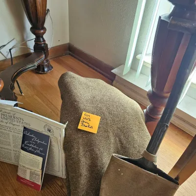World War I era military items, including a 1917 olive drab wool army blanket, an entrenching shovel with a canvas cover, and historical...