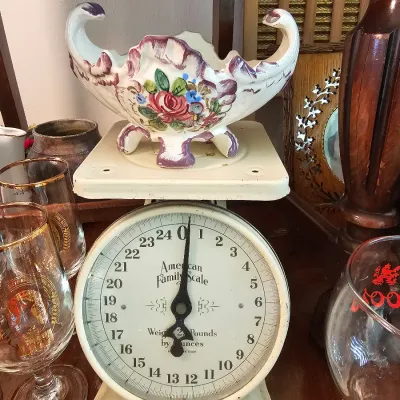 Vintage American Family Scale in off-white, supporting a hand-painted floral ceramic footed bowl with purple accents.