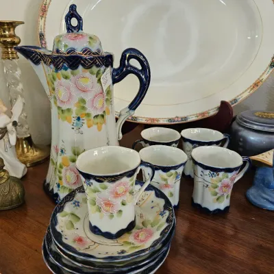 Vintage hand-painted porcelain chocolate pot set featuring a floral design with cobalt blue and gold trim, including five matching cups...