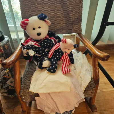 Two patriotic Ty Beanie Babies, including a larger "Libertae" bear and a smaller "Spangle" bear, displayed on a...