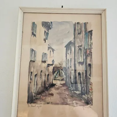 Framed watercolor painting depicting a European street scene, signed and dated "St. Paul 1950" in the lower left corner.