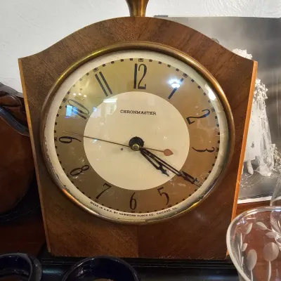 Vintage Hammond Chronmaster electric mantel clock featuring a wood case with a brass bezel and top finial, circa 1930s.