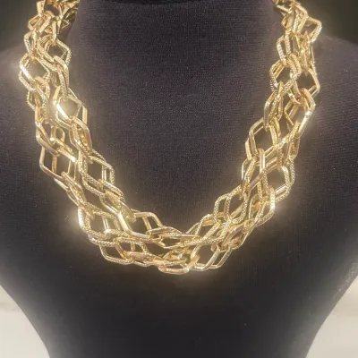 Sale Photo Thumbnail #157: Vintage gold-tone multi-strand chain necklace featuring textured, interlocking diamond-shaped links, displayed on a black jewelry bust.
