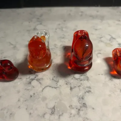 Sale Photo Thumbnail #52: Four vintage miniature art glass animal figurines, including squirrels and birds, in shades of amber and red.