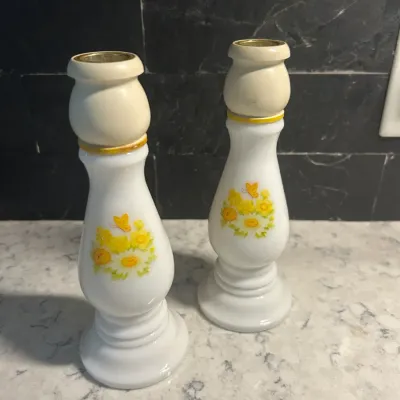Sale Photo Thumbnail #21: Pair of vintage milk glass candlesticks featuring a yellow floral and butterfly motif with gold-trimmed accents.