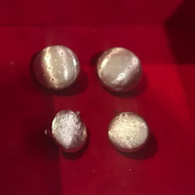 Sale Photo Thumbnail #26: Two pairs of vintage silver-tone round cufflinks, one pair featuring a textured, dimpled pattern and the other with a brushed satin finish, displayed on a red velvet surface.
