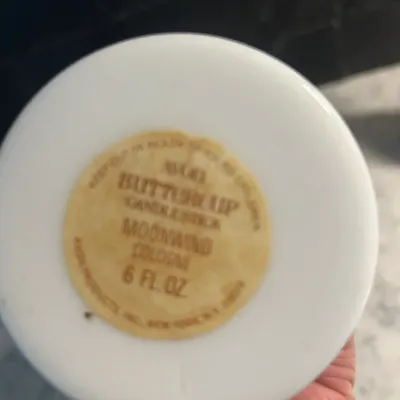 Sale Photo Thumbnail #22: Vintage Avon Buttercup Candlestick Moonwind Cologne bottle base, showing the original paper label for the 6 fl. oz. size.