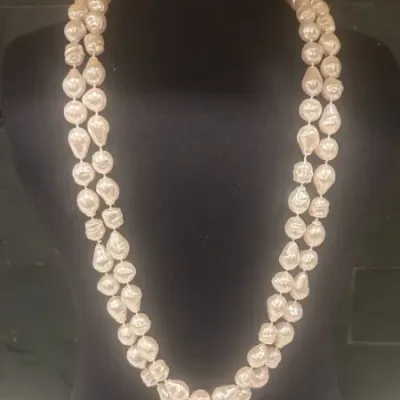 Sale Photo Thumbnail #33: Double-strand baroque pearl necklace displayed on a black velvet jewelry bust.