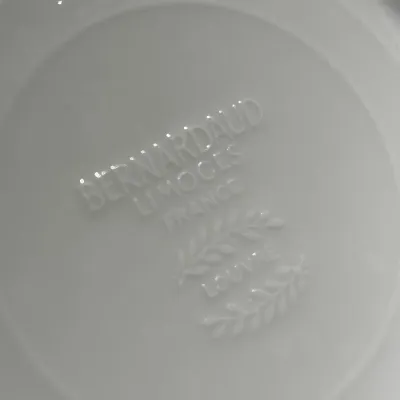 Embossed maker's mark on the underside of a Bernardaud Limoges France porcelain piece in the Louvre pattern.