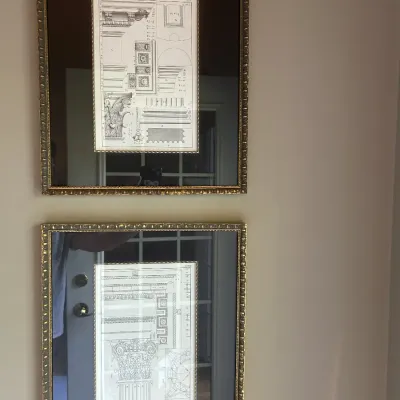 Pair of framed architectural prints depicting classical column capitals and entablatures, presented in ornate gold-finished frames with...