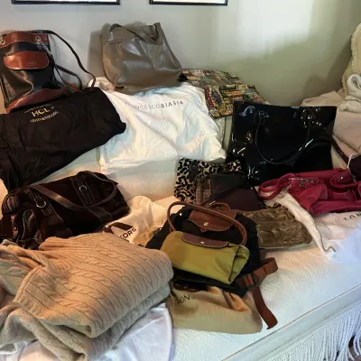 Assortment of designer handbags and accessories, including a Francesco Biasia dust bag, a Longchamp backpack, and various leather and...