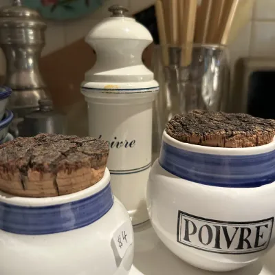Vintage French ceramic kitchen canisters labeled 'Sel' and 'Poivre' with blue trim and cork lids, shown alongside a...
