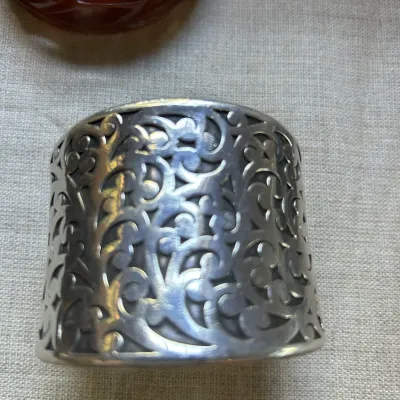 Vintage sterling silver wide cuff bracelet featuring an intricate openwork filigree scroll design.