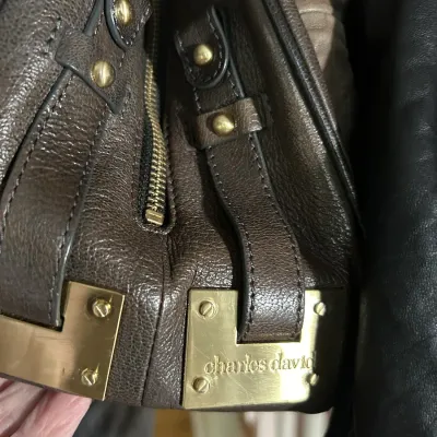 Sale Photo Thumbnail #102: Charles David brown pebbled leather handbag featuring gold-tone hardware and branded metal plates.