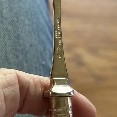 Close-up of a silver-plated utensil handle showing the maker's mark "EPNS A1 Sheffield England" alongside other hallmarks.