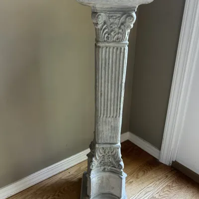 Classical-style concrete pedestal column featuring a fluted shaft and ornate Corinthian-inspired capital and base.