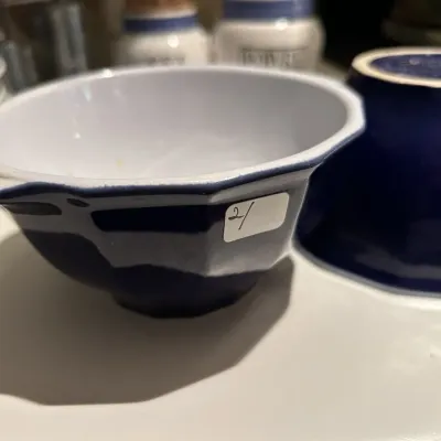Two vintage cobalt blue and white ceramic bowls, featuring a paneled design and small side handles.