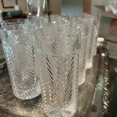 Set of vintage pressed glass highball tumblers featuring a textured herringbone pattern, displayed on a tarnished silver-plated tray.