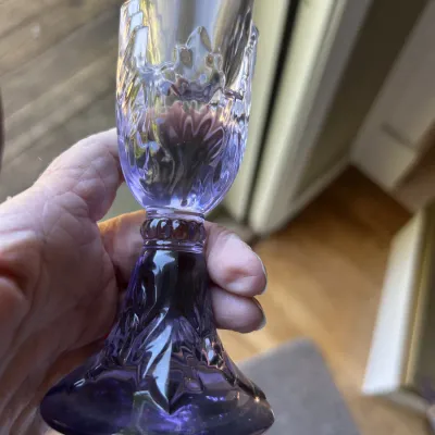 Vintage purple pressed glass goblet featuring an ornate, textured stem and base.