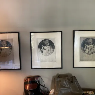 Trio of framed black and white circular etchings depicting classical figures, matted and housed in simple black frames.