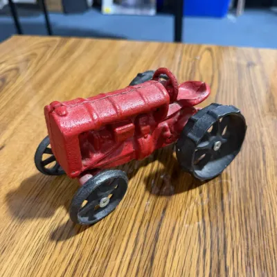 Sale Photo Thumbnail #321: Cast Iron Red Farm Tractor Model with Black Wheels & Steering Wheel – Estate Sales Warehouse (GR)