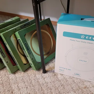 Sale Photo Thumbnail #46: Goovi robot vacuum, and several boxed sets of Holiday Time charger plates.