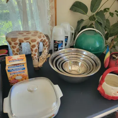 Sale Photo Thumbnail #60: nested set of stainless steel mixing bowls, CorningWare casserole dish with lid, a novelty giraffe stool, and vintage Aladdin thermos x2