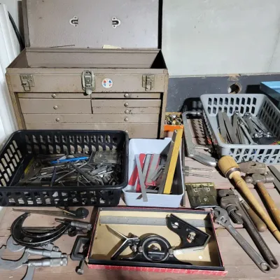 Sale Photo Thumbnail #156: Vintage machinist tools and toolboxe, including micrometer calipers, a combination square set, files, wrenches, and a metal chest with drawers.