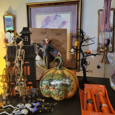 Sale Photo Thumbnail #43: Jim Shore Dracula figure, a carved decorative pumpkin, and a haunted house with skeletons.
