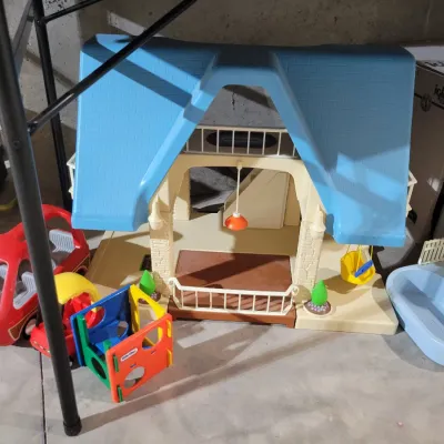 Sale Photo Thumbnail #127: Vintage Little Tikes plastic dollhouse with blue roof, accompanied by a red toy car, a small playground structure, and a swimming pool accessory.