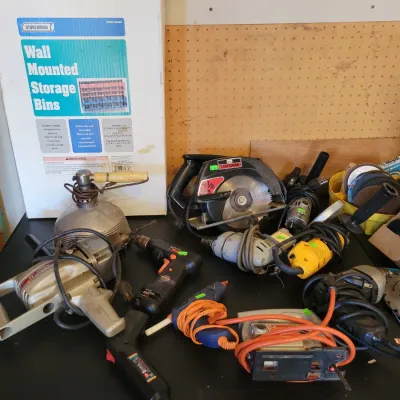 Sale Photo Thumbnail #191: power tools, including a Craftsman circular saw, various drills, a jigsaw, and a boxed wall-mounted storage bin set.
