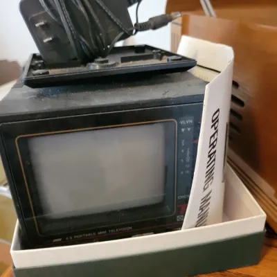 Sale Photo Thumbnail #87: Vintage 4.5-inch portable mini television with its original operating manual, and power adapter.