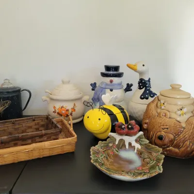 Sale Photo Thumbnail #65: Bear-shaped cookie jar, a bumblebee honey pot, a snowman cookie jar, and baskets.