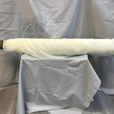 Large bolt of sheer white fabric, suitable for drapery, event decor, or sewing projects.