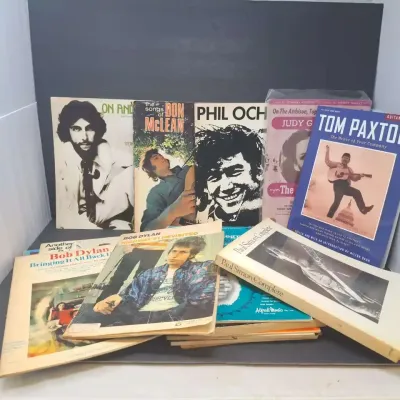 Collection of vintage folk and rock music songbooks and sheet music, featuring artists such as Bob Dylan, Paul Simon, Phil Ochs, and Tom...