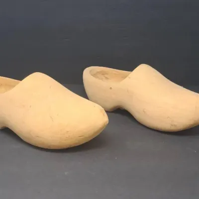 Pair of vintage hand-carved wooden clogs, showing natural wood grain and light wear.