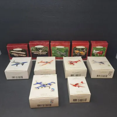 Collection of eleven Hallmark Keepsake airplane Christmas ornaments in their original boxes, featuring various vintage and modern...