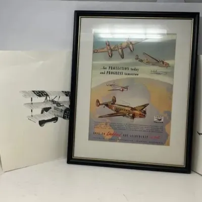 Framed vintage Lockheed aviation advertisement print, flanked by three unframed black and white sketches of historical military biplanes.