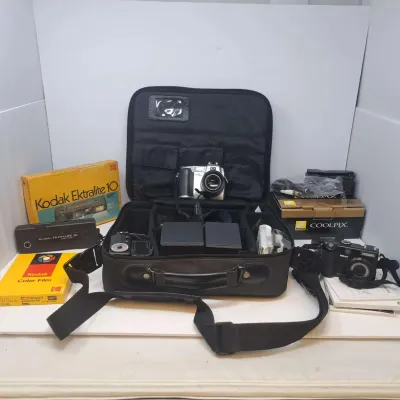 Vintage camera collection including a Kodak Ultralite 10 camera with its original box, a Nikon Coolpix digital camera with its box, and a...