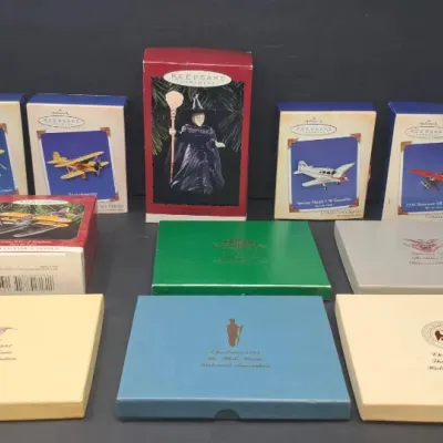 Collection of boxed Hallmark Keepsake ornaments, including airplane models and a Wicked Witch of the West figure, alongside several White...